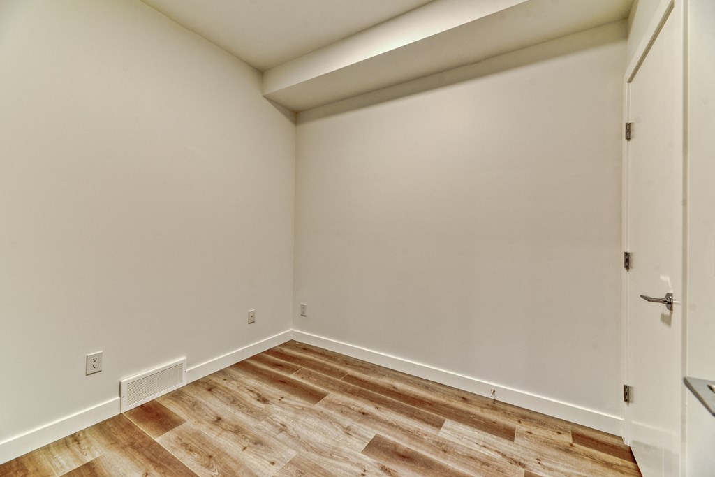 A room with a wooden floor and a white door.