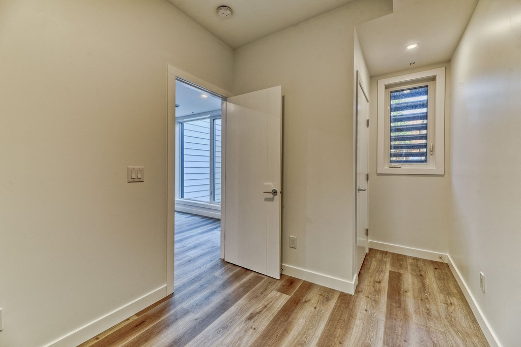 A room with a white door and a window with blinds.