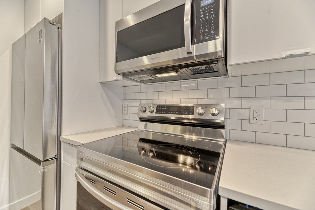 A stainless steel kitchen with a microwave, oven, and refrigerator.