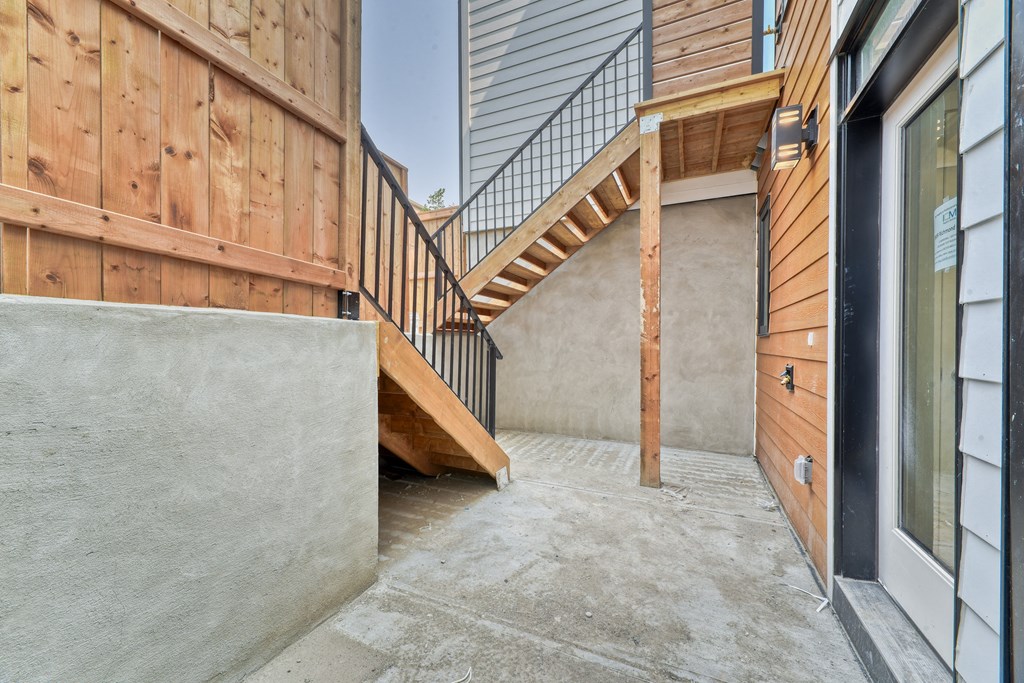 A concrete staircase leads up to a wooden deck.