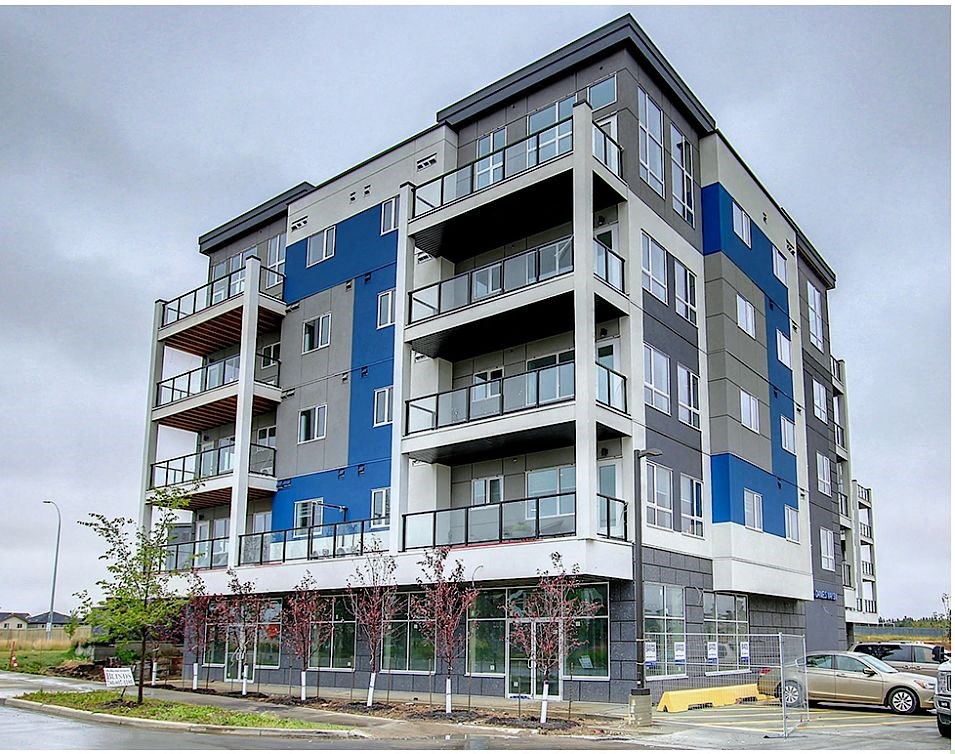 A large apartment building with balconies and multiple windows.