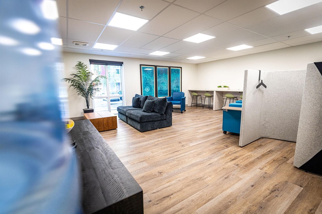 a room with couches and a desk in a office with wood floors