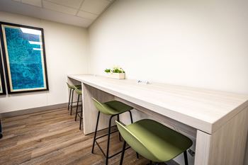 an office with a long desk and green chairs