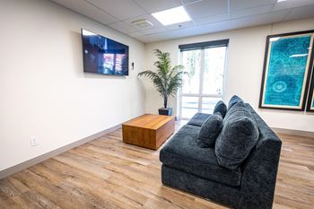 a living room with a couch and a tv on the wall