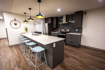 a modern kitchen with a large island and bar stools