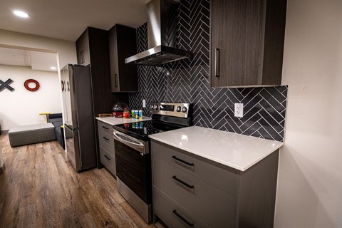 A modern kitchen with dark wood cabinets and a white countertop.