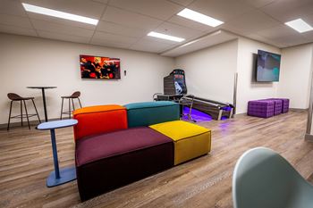 a living room with couches and chairs and a video game on a table
