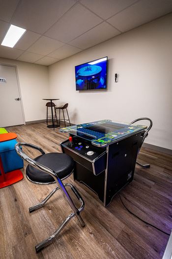 a room with a game system and a tv on the wall