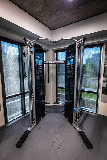 a fitness room with cardio machines and a window