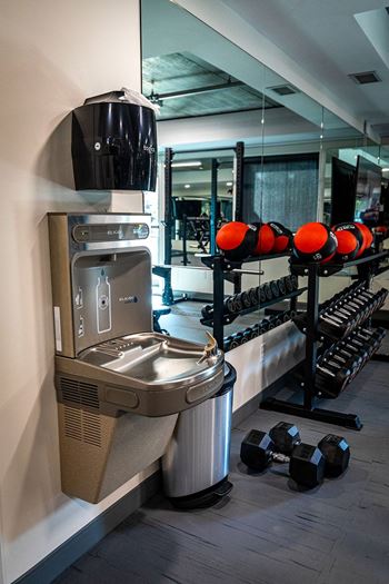 a fitness room with a water fountain and a rack of dumbbells