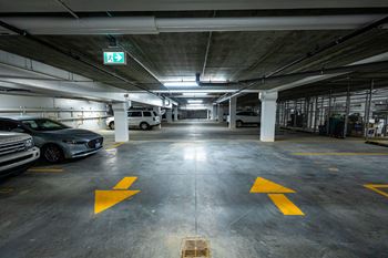 a parking garage with cars and a exit sign