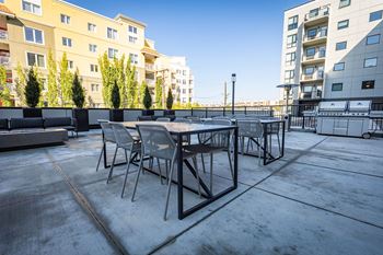 a patio with a table and chairs on a rooftop