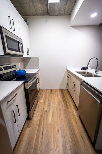 a kitchen with wooden floors and stainless steel appliances