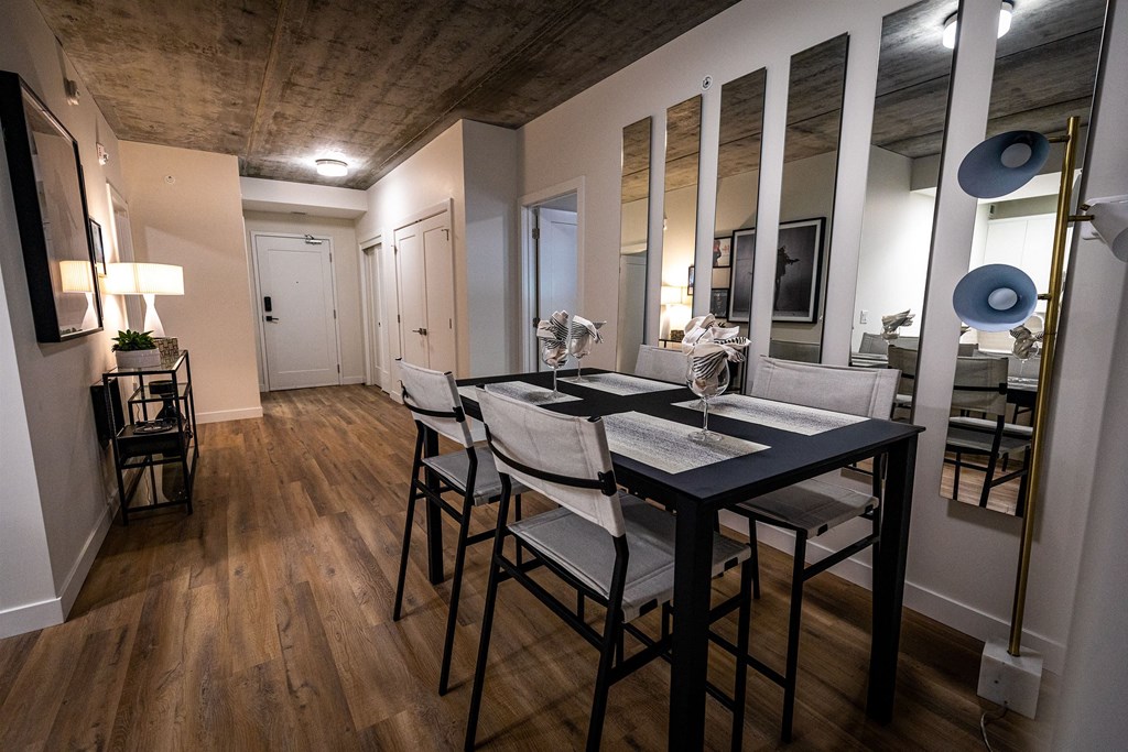 a dining room with a table and chairs and a large mirror