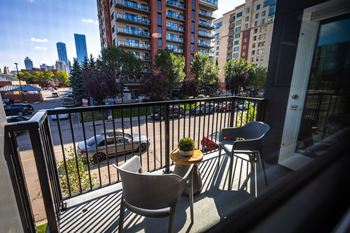 a balcony with a table and chairs and a city view