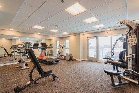A spacious gym with a variety of equipment including treadmills, weights, and exercise machines.