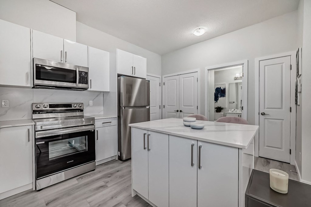 a kitchen with white cabinets and stainless steel appliances