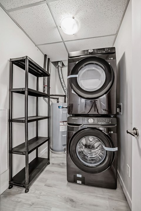 a small laundry room with a washing machine and a shelf