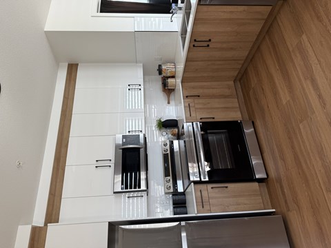 A modern kitchen with wooden cabinets and stainless steel appliances.