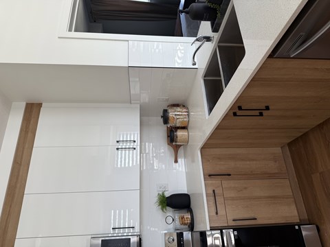 A kitchen with a white counter top and wooden cabinets.