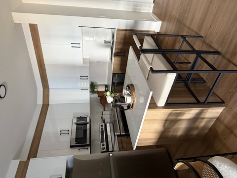 A modern kitchen with a wooden floor and white walls.