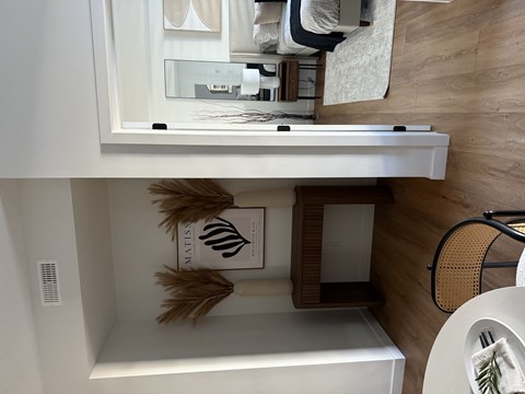 A white bathroom with a white tub and a white towel hanging on a rack.