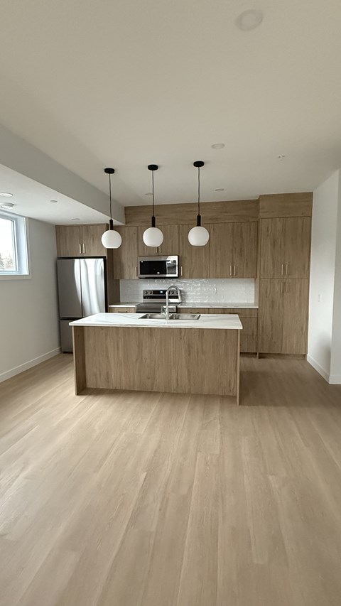 A kitchen with wooden cabinets and a light brown floor.