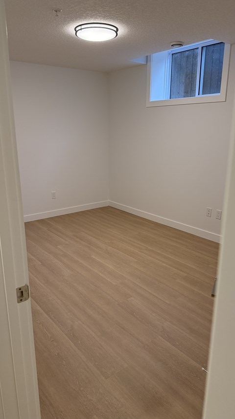 A room with a light brown floor and white walls.
