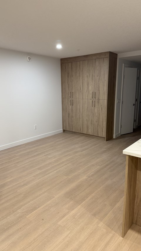A room with wooden flooring and a wooden cabinet.