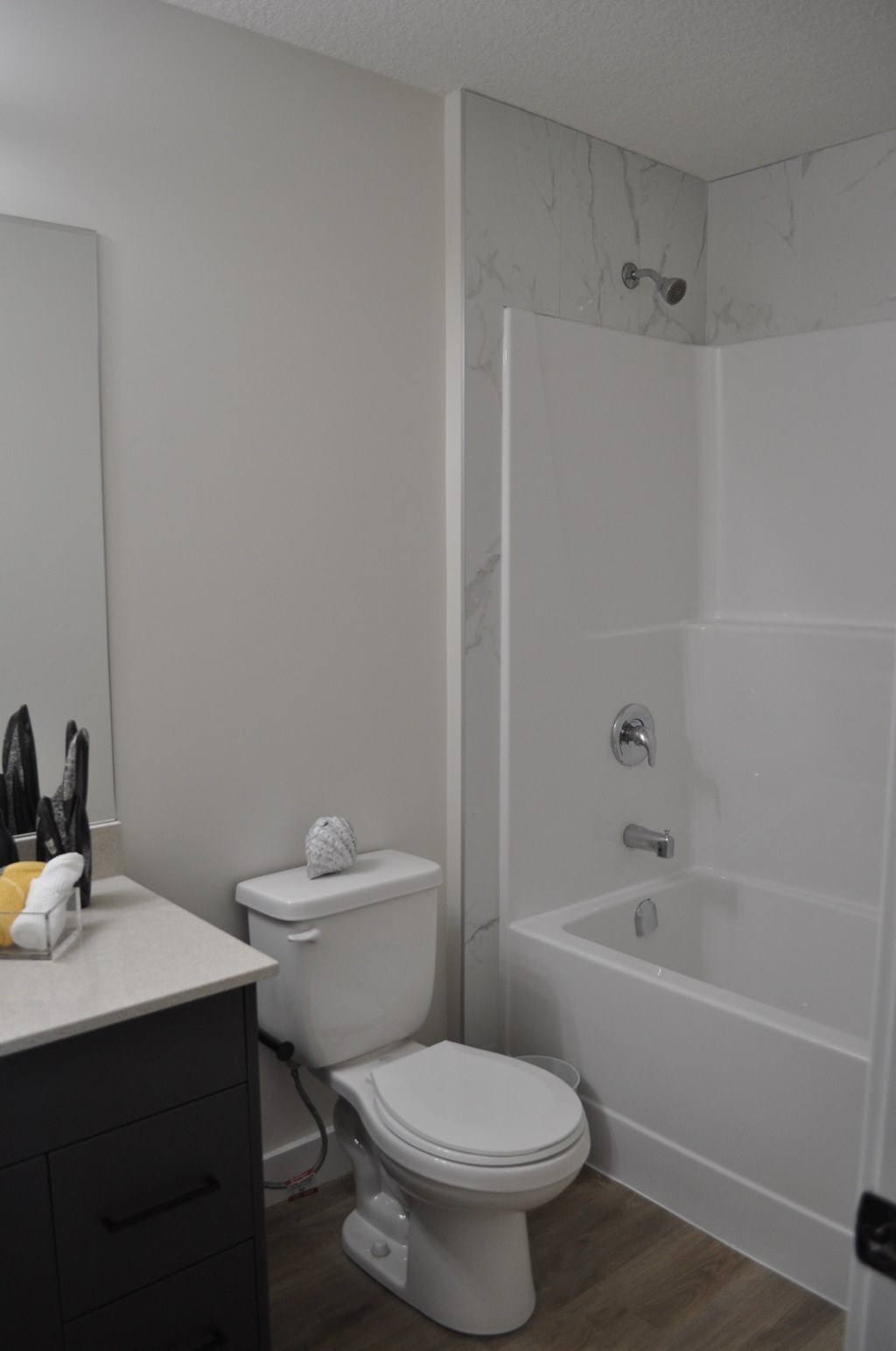 A white toilet sits next to a white bathtub in a bathroom at The Laurent at Laurel Apartments, Alberta, T6T 2T5