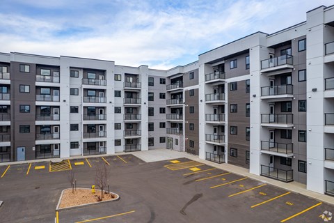 A parking lot in front of apartment buildings.