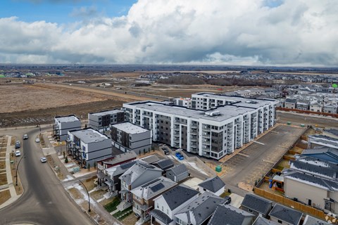 A large white building with a parking lot in front of it.