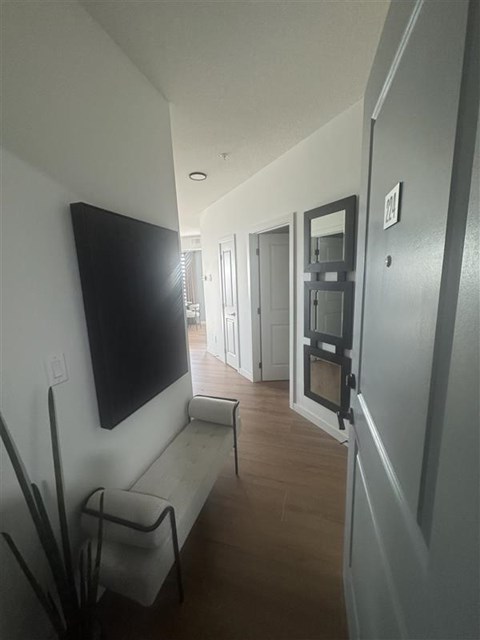 A long hallway with a flat screen TV on the wall.