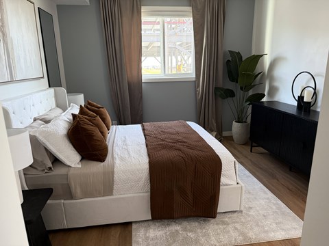 A bed with a white headboard and brown comforter in a room.