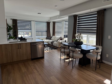 A kitchen with a dining table and chairs.