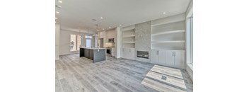 A spacious kitchen with a grey island and white cabinets.