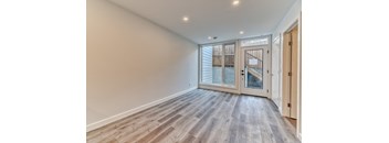 A room with a wooden floor and a glass door leading outside.