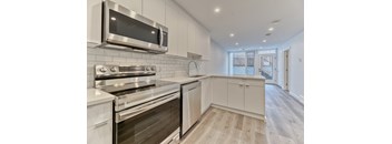 A modern kitchen with stainless steel appliances and white cabinetry.