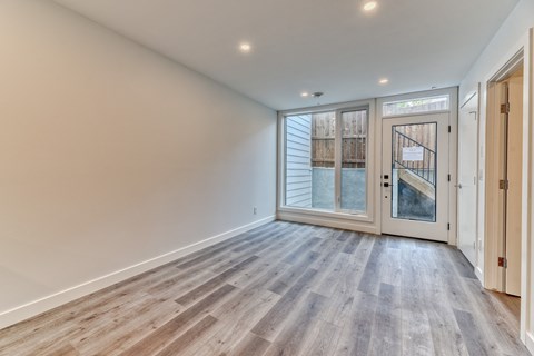 A room with a wooden floor and a glass door leading outside.