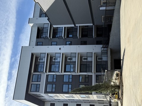 A modern building with a grey and white exterior and multiple windows.