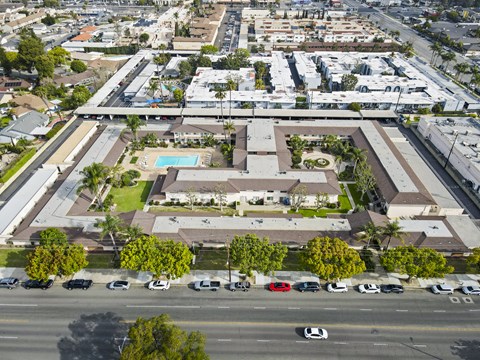 A large building with a pool in the middle of a grassy area.