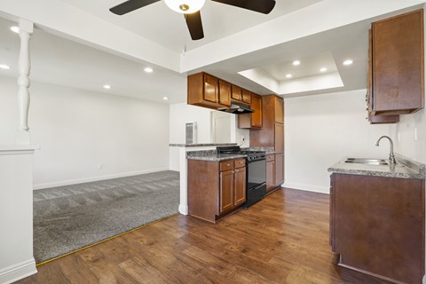 A kitchen with wooden cabinets and a white ceiling fan.