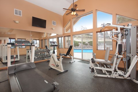 A spacious gym with a treadmill, weights, and exercise equipment.