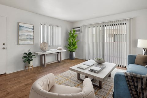 A living room with a white couch, a coffee table, and a potted plant.