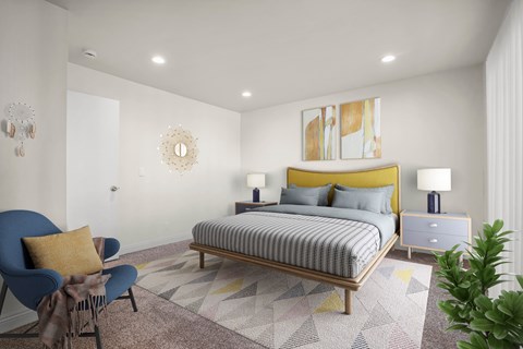 A bedroom with a bed, chair, and lamp.