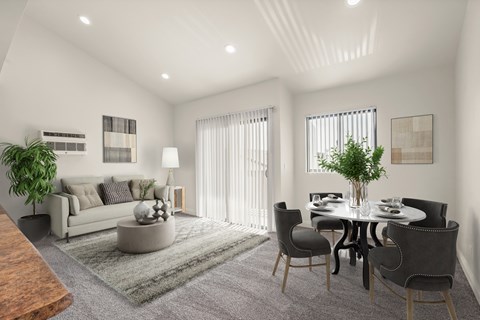 A modern living room with a grey sofa, a grey coffee table, a grey rug, a grey dining table with grey chairs, a potted plant, and a wooden coffee table.
