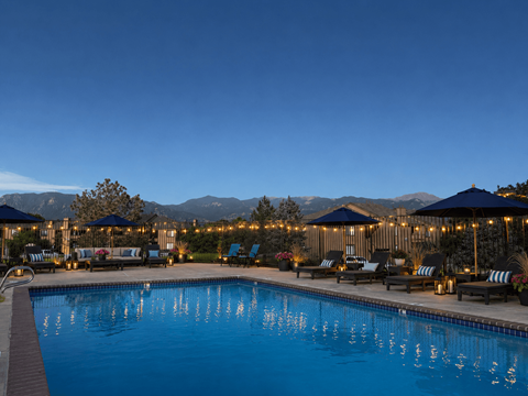 A large swimming pool surrounded by lounge chairs and umbrellas.