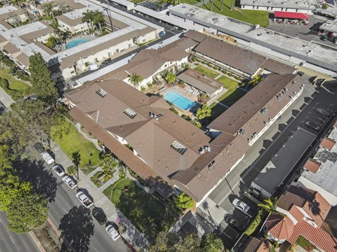 An aerial view of a residential area with houses and a swimming pool.