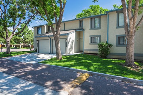 A sunny day at a residential area with apartment buildings and green trees.