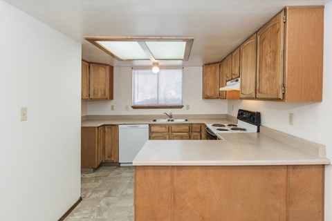 A kitchen with wooden cabinets and a white countertop.